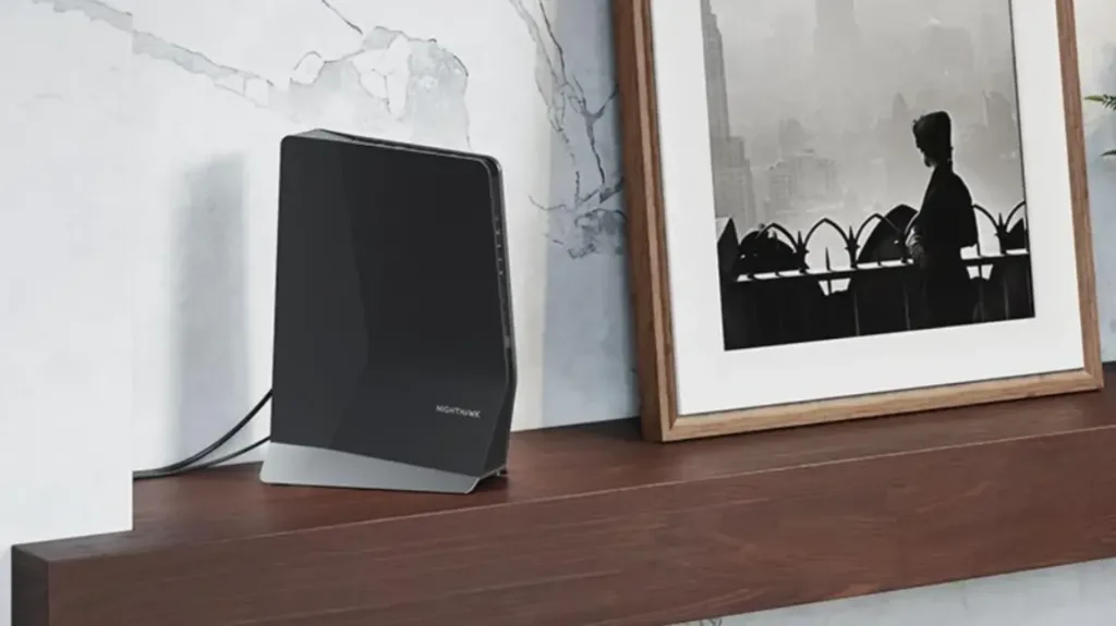 A Netgear wi-fi extender on a desk next to a photograph