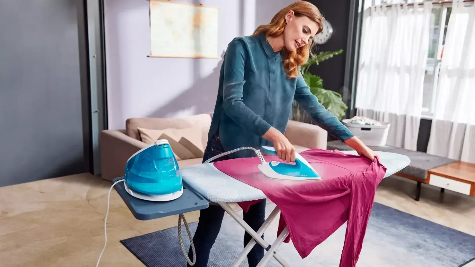 The Philips Perfect care iron being used by a blonde lady in a sparsely furnished room..