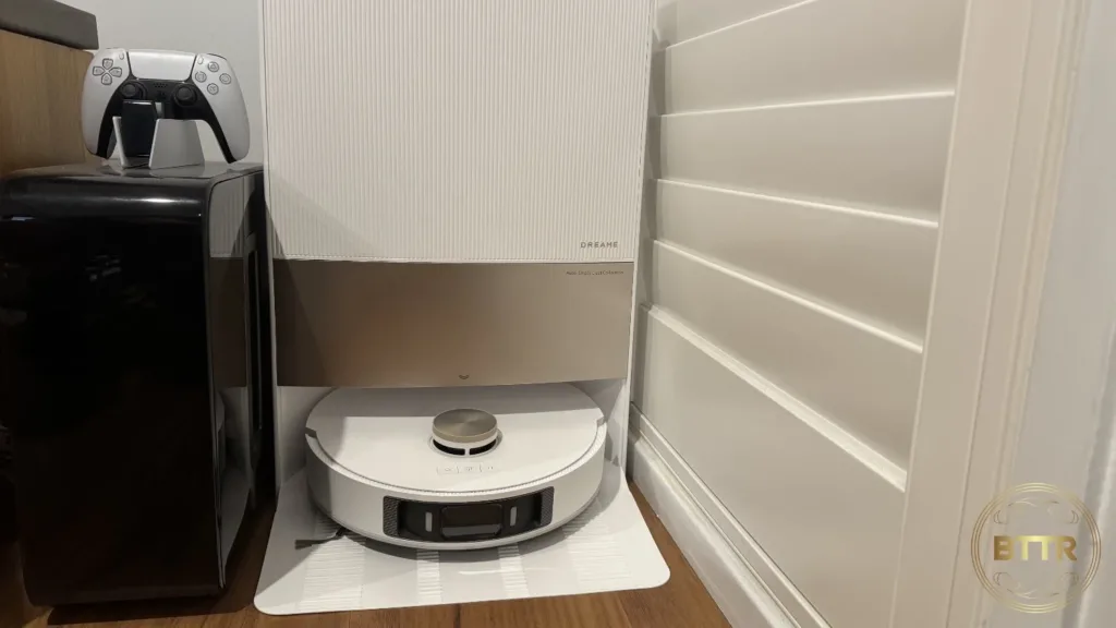 The L20 Vacuum in its base station next to a speaker and the wall