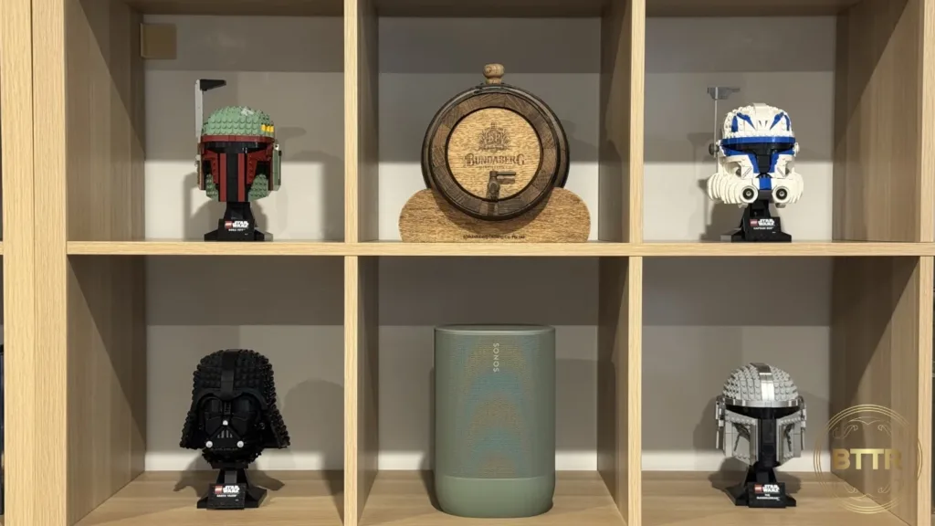 The Sonos Move 2 speaker on an Ikeas Kallax shelf with Lego Star Wars Helmets and a whiskey barrel
