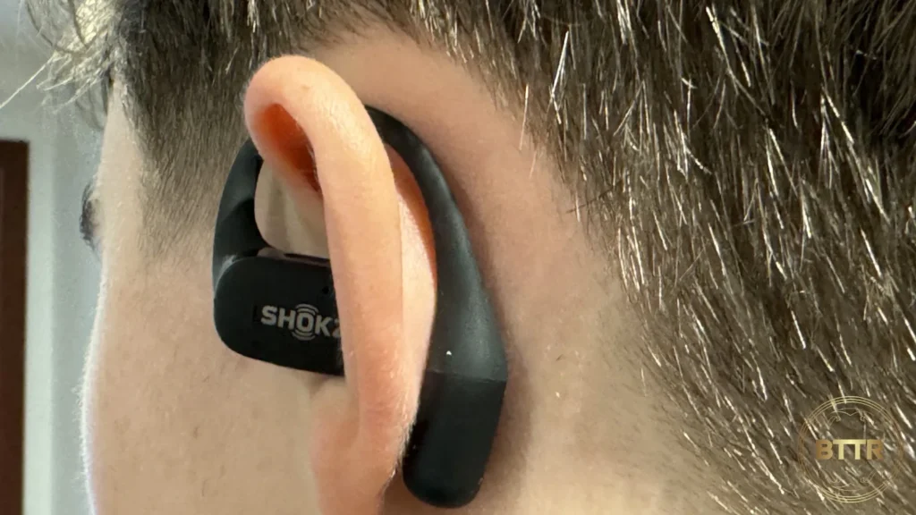 The left Shokz Openfit earbud being worn, viewed from behind